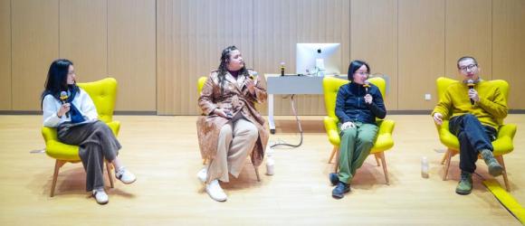 Four speakers sitting on the stage