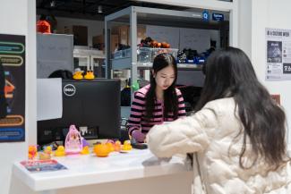An Equipment Room staff helping out a student at the window