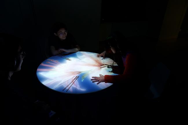 Seated at the dinner table, the audience engaged with the projected video and shared their reflections.