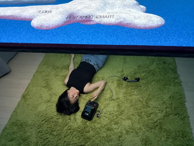 The viewer lying down, reaching the phone
